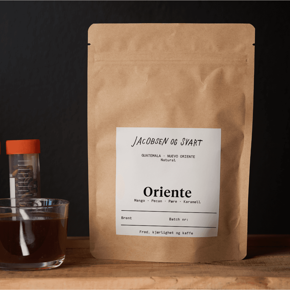 Kraft kaffe pose med etikett ved siden av kaffe i glass